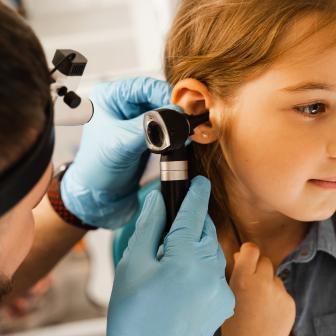 Arzt untersucht Ohr des Mädchens