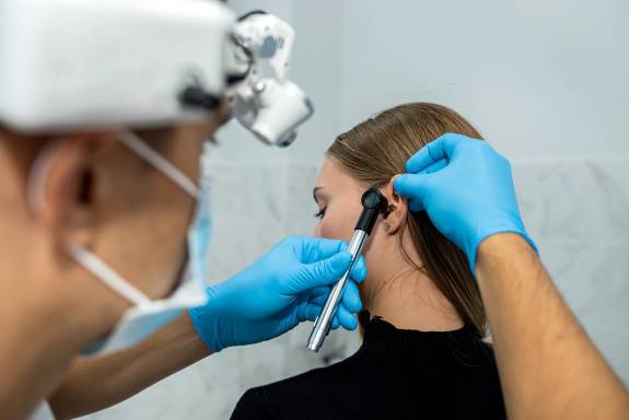 Arzt untersucht Ohr der Patientin