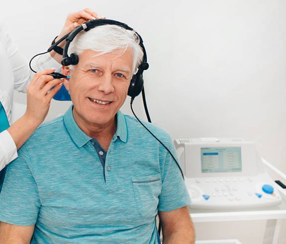 Ärztin untersucht Ohr des Patienten